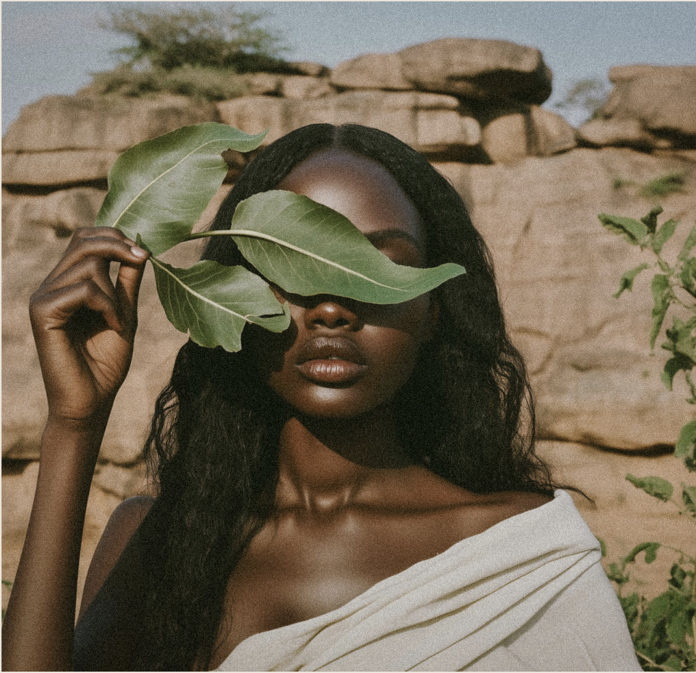 Woman with glowing skin holding a leaf